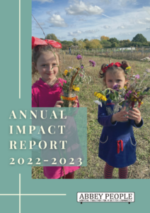 Cover of a report with two young girls holding dried flowers and the words reading 'Annual Impact Report 2022-2023"